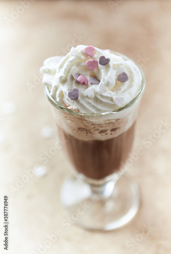 Coffee with whipped cream on bright stone background. Soft focus. Close up. 