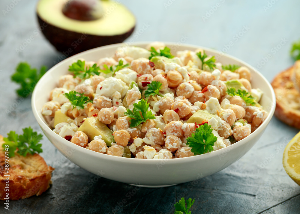 Chickpeas salad with feta cheese, avocado and herbs in white bowl. healthy food Chickpeas salad with feta cheese, avocado and herbs in white bowl. healthy food