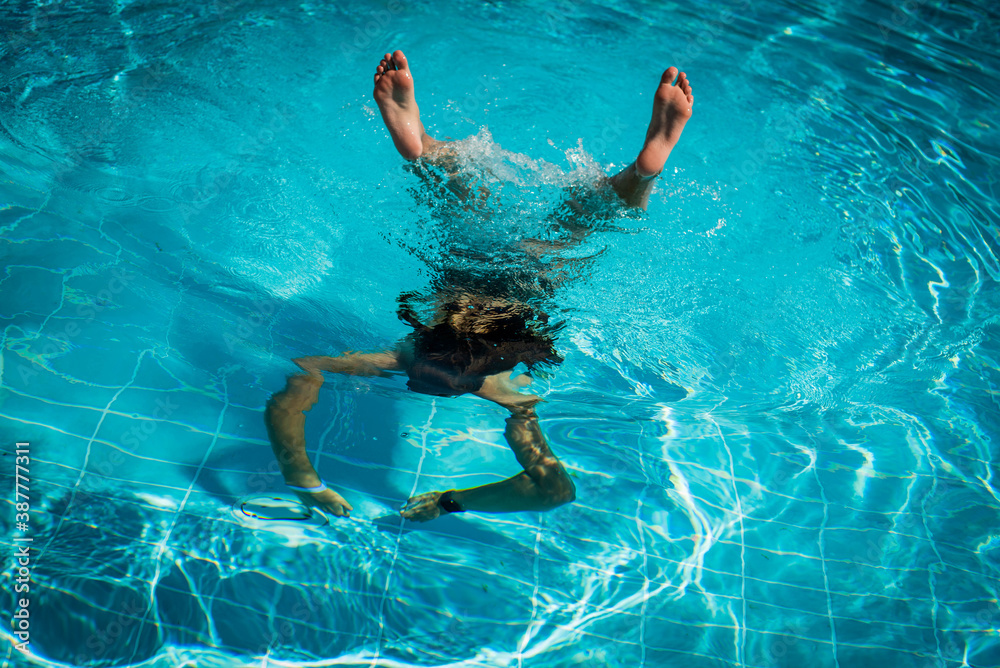 Fashion portrait of graceful cute girl in .underwater in swimming pool during holidays on luxury resort. enjoying. happy, positive emotion, summer style Vacation, fun, lifestyle concept.