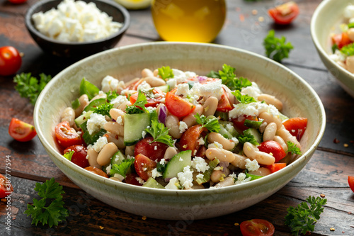 White Bean Salad with Cherry Tomatoes, Cucumber, Red onion, Feta cheese and parsley. Healthy vegetarian, vegan diet food
