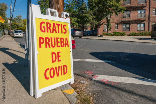 Sign on street corner reading Gratis Pueba de Covid in Spanish or Free Covid Test in English.