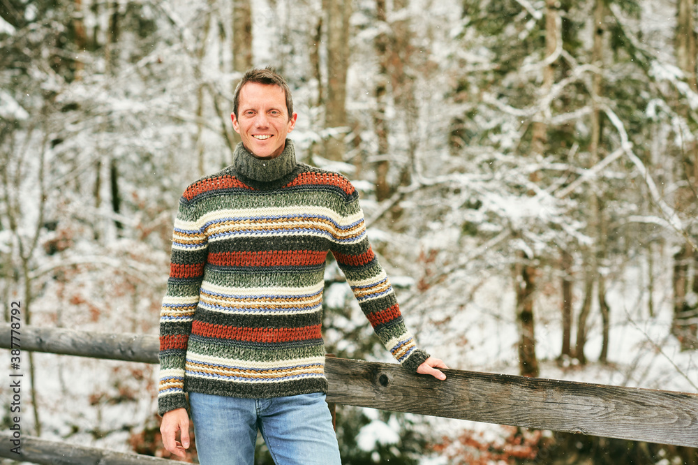 Φωτογραφία Outdoor winter portrait of middle age man in snowy forest, wearing warm knitted