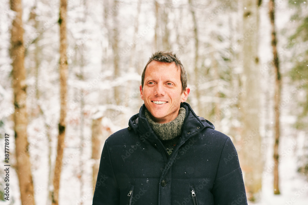 Outdoor winter portrait of middle age man in snowy forest, wearing jacket Outdoor winter portrait of middle age man in snowy forest, wearing jacket