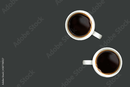 Two coffee mugs and copy space, against the dark background