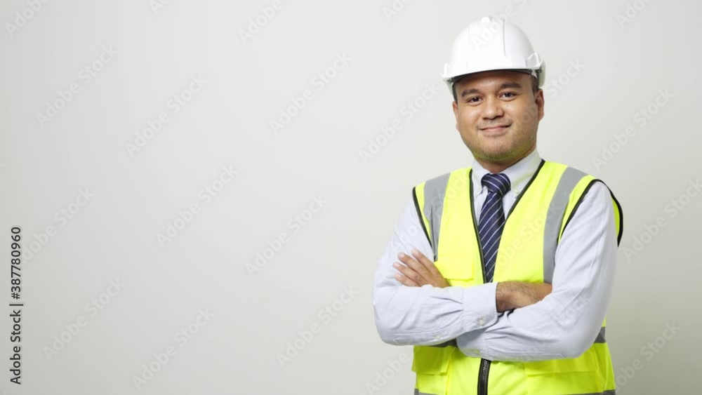 Asian worker in uniform hard hat pointing the finger to blank space for advertise text or mockup in studio isolated white background. 4k resolution. Asian worker in uniform hard hat pointing the finger to blank space for advertise text or mockup in studio isolated white background. 4k resolution.