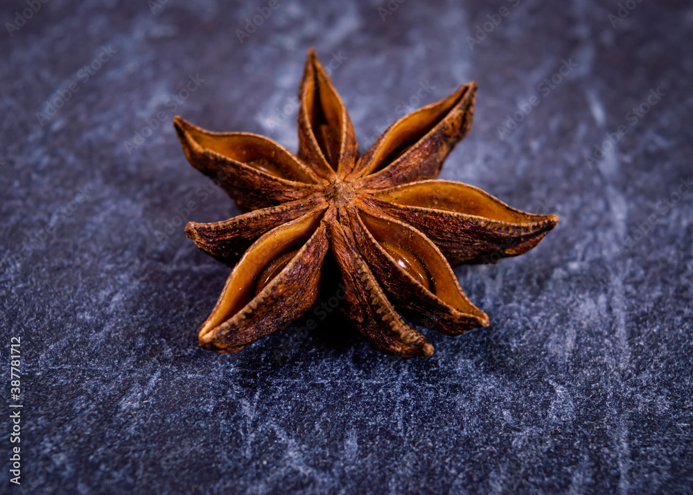 Close-up of star anise seed pod against a dark surface Close-up of star anise seed pod against a dark surface