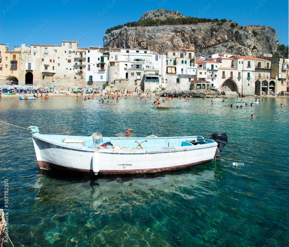 Fototapeta premium Characteristic view of the coastal city of Cefalù near Palermo in Sicily. It has a cristal clear blue water and nice old houses in front of the sea 