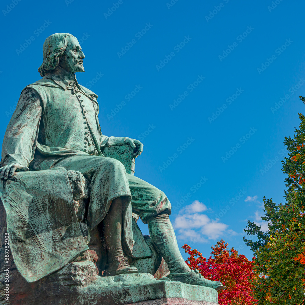 Naklejka premium Statue of great scientist Otto von Guericke in red and golden Autumn colors in historical downtown of Magdeburg Germany, at sunny day and blue sky, closeup, details..