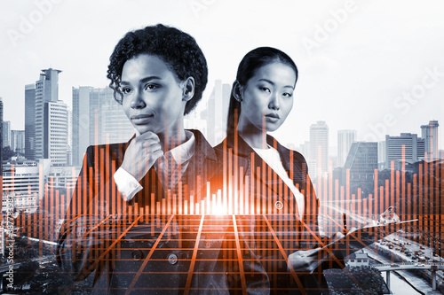 Photography Two young attractive businesswoman in suits pondering about new venture capital and hi-tech start up and try to forecast risks and estimate prospective earning growth