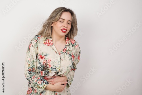 Young beautiful woman wearing casual clothes over yellow background suffering from strong stomachache.