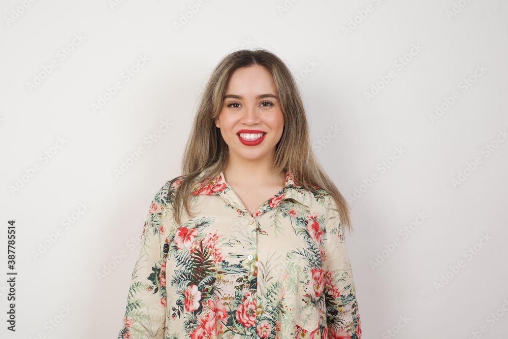 Beautiful Young caucasian woman with happy and funny face smiling and showing tongue. Wearing casual clothes and standing against gray studio background. Beautiful Young caucasian woman with happy and funny face smiling and showing tongue. Wearing casual clothes and standing against gray studio background.