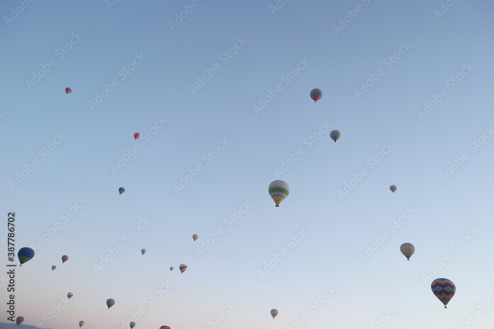 Hot air balloons flight in the sky. Colorful hot air balloons flying on blue sky background. Hot air balloons flight in the sky. Colorful hot air balloons flying on blue sky background.