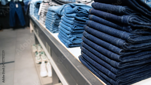 A stack of jeans in a clothing store. Banner for black Friday ads. Selective focus. Copy space. photo