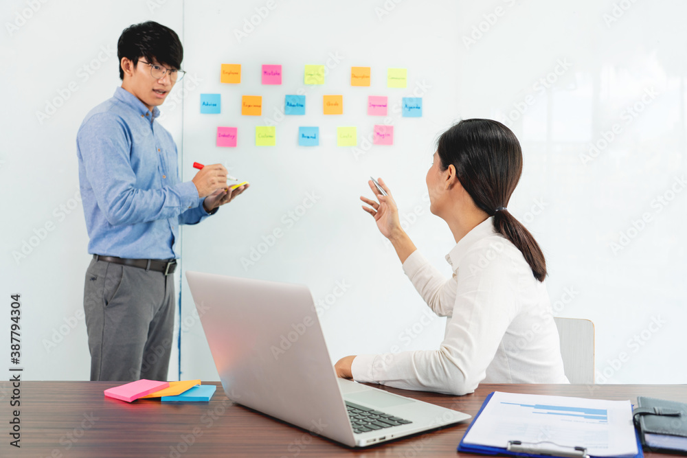 Business manager showing idea for her team and stick many memo paper on glass window to success working in business meeting  creative office, planning and management concept.