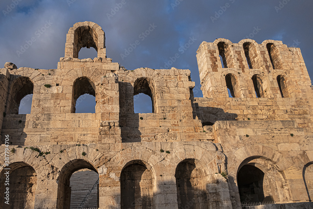 Picturesque view of Greek ruins of Odeon of Herodes Atticus (161AD) - stone Roman theater at the Acropolis hill on sunset. Athens, Greece.