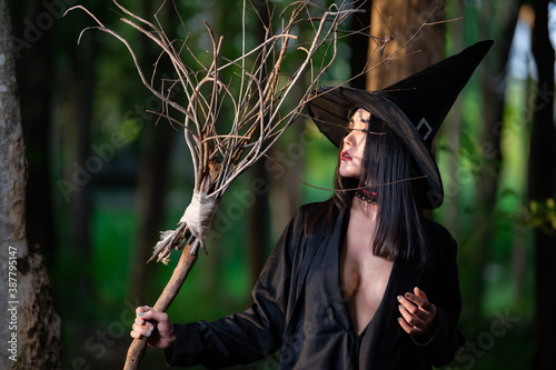 Portrait of beautiful asian sexy woman wear black witch costume with broom,Halloween festival concept