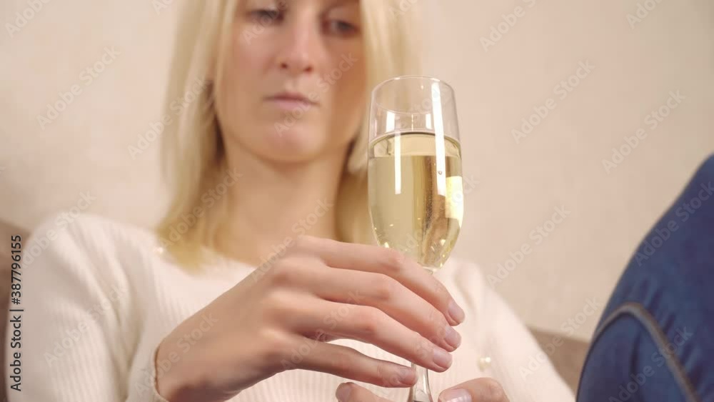 young beautiful single blonde holding a glass of sparkling wine champagne. close up. The concept of a lonely Christmas. Self-isolation, pandemic. young beautiful single blonde holding a glass of sparkling wine champagne. close up. The concept of a lonely Christmas. Self-isolation, pandemic.