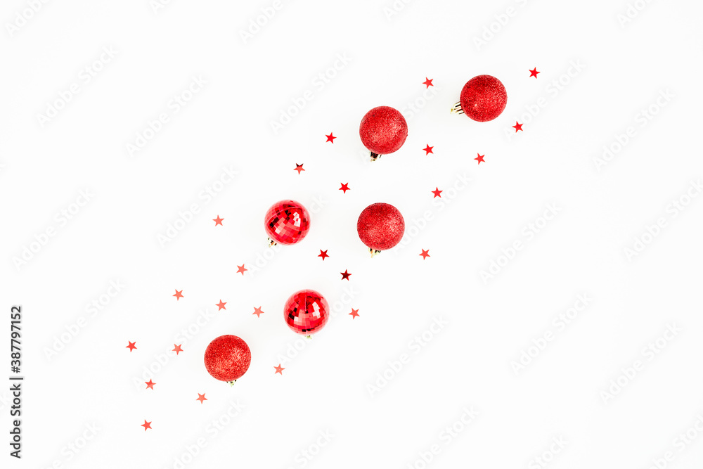 Christmas winter concept made of red balls decoration and blurry confetti on white background. Flat lay