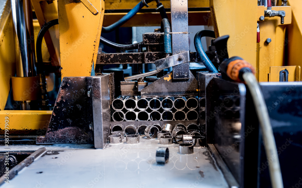 Automatic band saw machine with water coolant cutting metal pipes. Automatic band saw machine with water coolant cutting metal pipes.