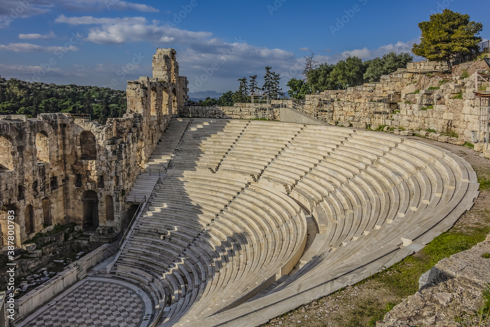 Top view of Greek ruins of Odeon of Herodes Atticus (161AD) - stone Roman theater at the Acropolis hill on sunset. Athens, Greece.