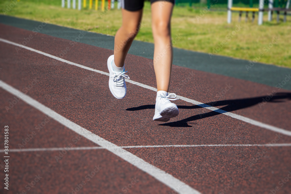 A runner's feet run along the road in close-up on their shoes. Running training, healthy lifestyle.