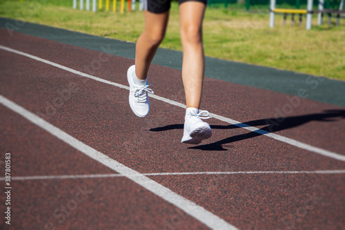 A runner's feet run along the road in close-up on their shoes. Running training, healthy lifestyle.