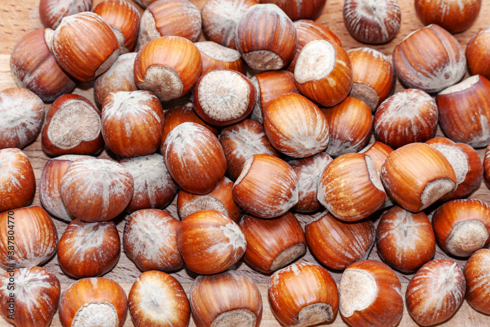 Hazelnuts lay evenly on a wooden surface. Close-up. Can be used as a natural background, texture. Hazelnuts lay evenly on a wooden surface. Close-up. Can be used as a natural background, texture.