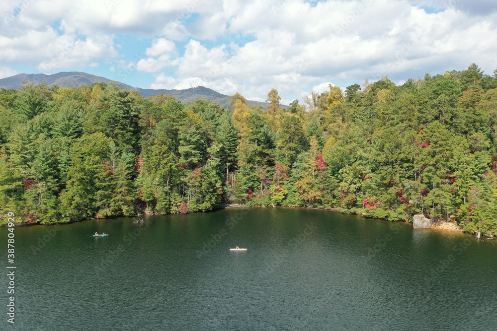 Aerial view of three young women canoeing and kayaking on Lake Santeetlah, North Carolina in autumn.