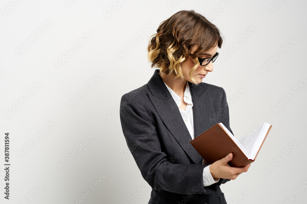 Business woman in a classic suit with a notebook in her hand and glasses on her face Copy Space Business woman in a classic suit with a notebook in her hand and glasses on her face Copy Space