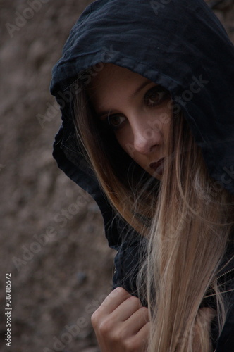 Close-up portrait of a beautiful young girl in black hood.