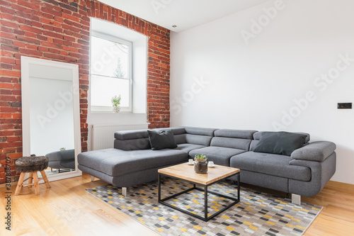 Big grey corner sofa in apartment © Photographee.eu