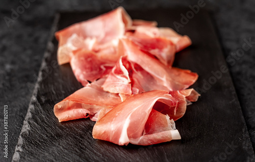 Spanish jamon Serrano, against a stone background 