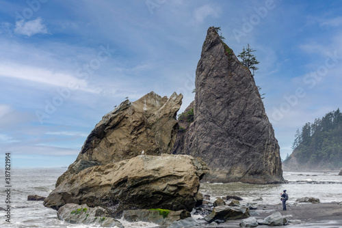 Haystack rocky coastal ocean beach with travel photographer. 