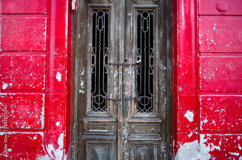 Old vintage wooden doors in abandoned building with bright red walls. Cordoba, Argentina