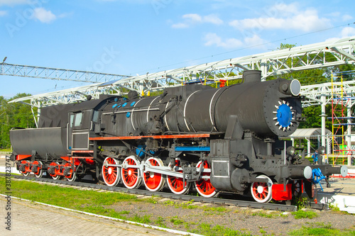 old steam locomotive at the station in the summer