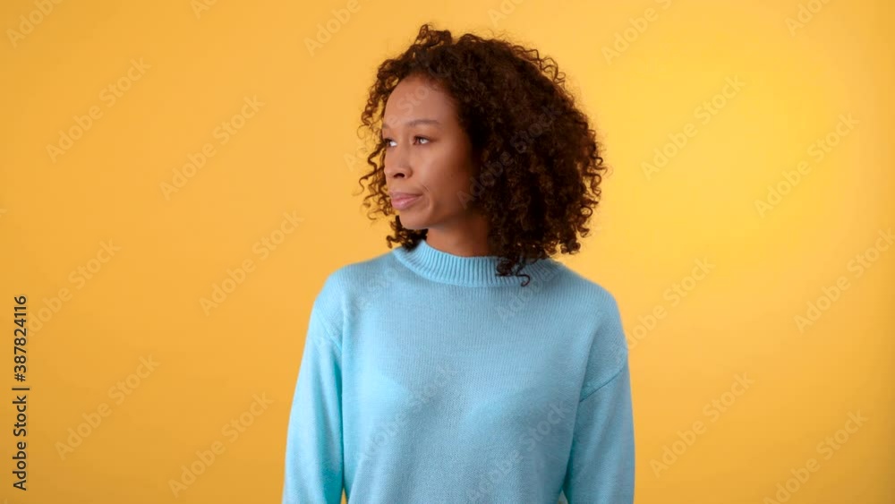 puzzled young woman on a yellow background. The woman chooses between two options. Isolated on a bright yellow background. 4K puzzled young woman on a yellow background. The woman chooses between two options. Isolated on a bright yellow background. 4K
