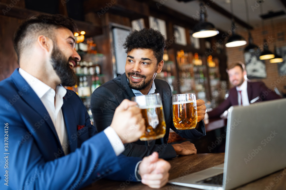 People, men, leisure, friendship and celebration concept. Happy male friends drinking beer at pub