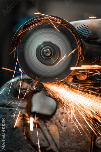Worker cutting steel, sparks from a grinder
