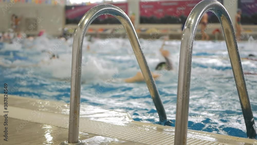 Slow motion. Swimming pool with lots of teenage swimmers. They swim fun in different styles and splash water Slow motion. Swimming pool with lots of teenage swimmers. They swim fun in different styles and splash water