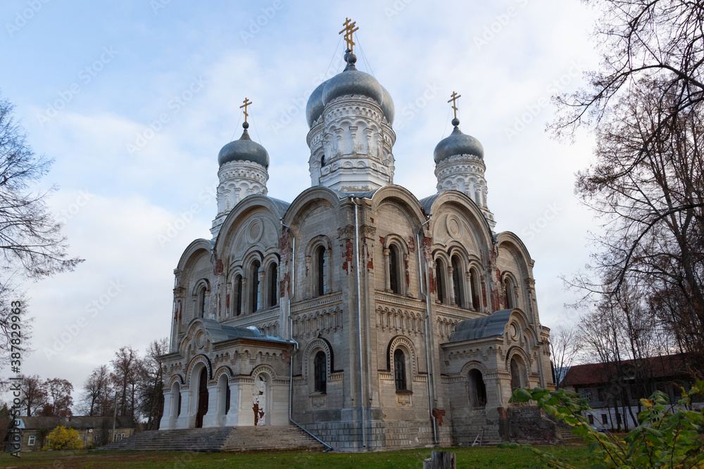 White stone church with silver domes in russian village Sergeevo in sunny autumn day