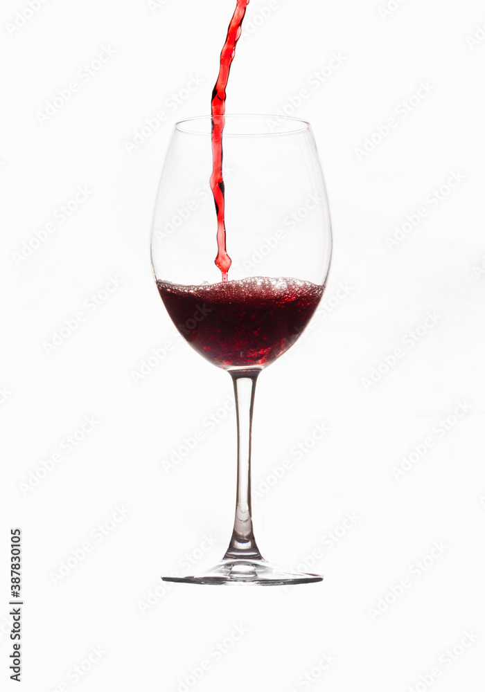 Filling a glass of red wine into a thin, clear crystal goblet Filling a glass of red wine into a thin, clear crystal goblet