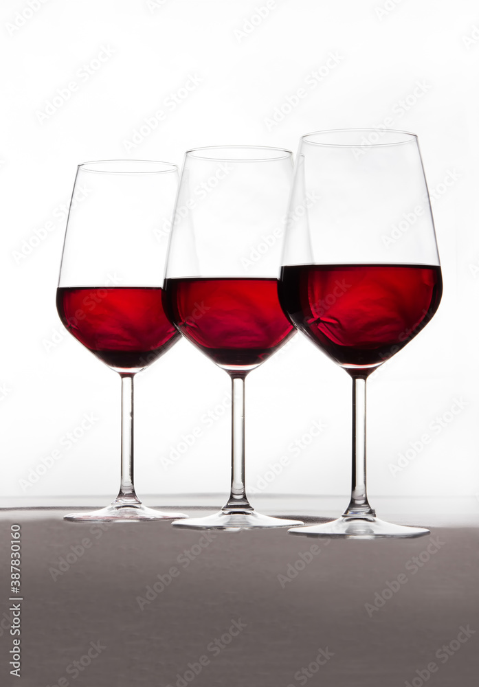 Three crystal glasses in harmony and full of wine on a white background