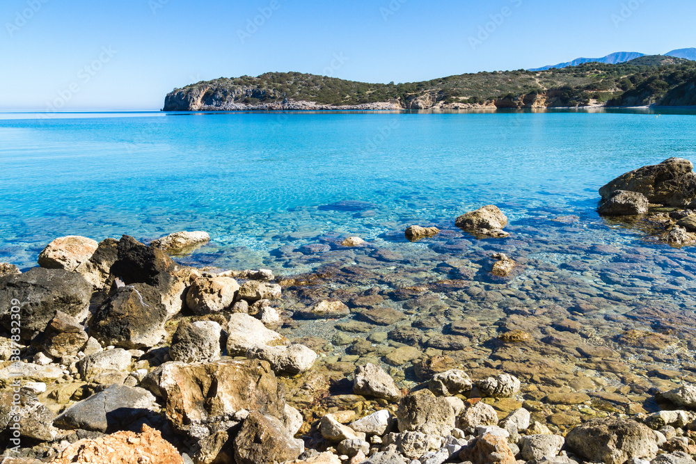 Beautiful idyllic turquoise waters coast with pebbles and rocks.