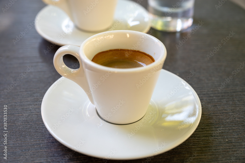 Drinking of strong black espresso coffee on outdoor terrace in cafe Drinking of strong black espresso coffee on outdoor terrace in cafe