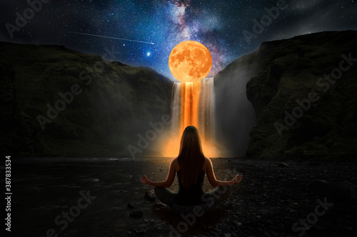 Woman doing yoga in front of a magic waterfall photo