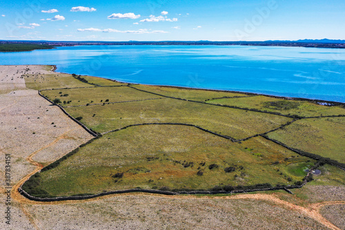 POVLJANA, PAG, CROATIA - OCTOBER 2020. - Aerial view of dry stone wall systems built for sheep breeding. Adriatic sea in distance. photo