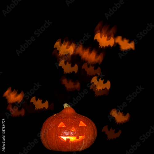 Halloween a pumpkin with burning eyes against a black sky and surrounded by fiery terrible flying mice photo