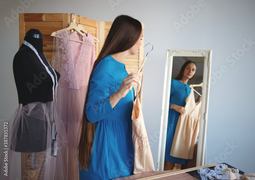 beautiful seamstress trying on a new product in front of the mirror