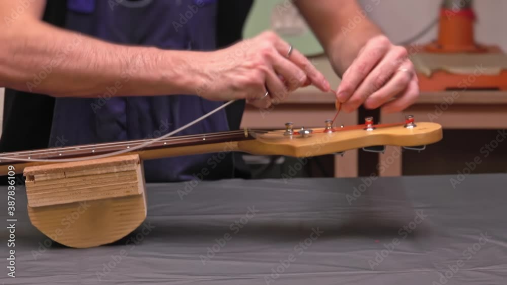 Putting new guitar string through the tuning machine post. Stock Video ...