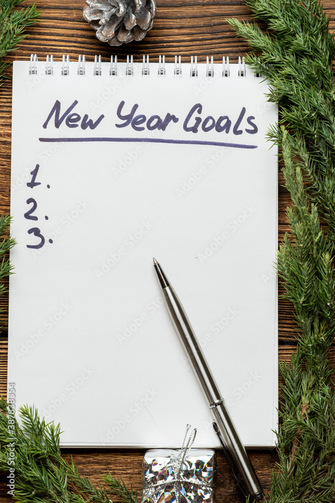 new year goals inscription in notebook with fir, spruce branches and Christmas tree toys new year goals inscription in notebook with fir, spruce branches and Christmas tree toys